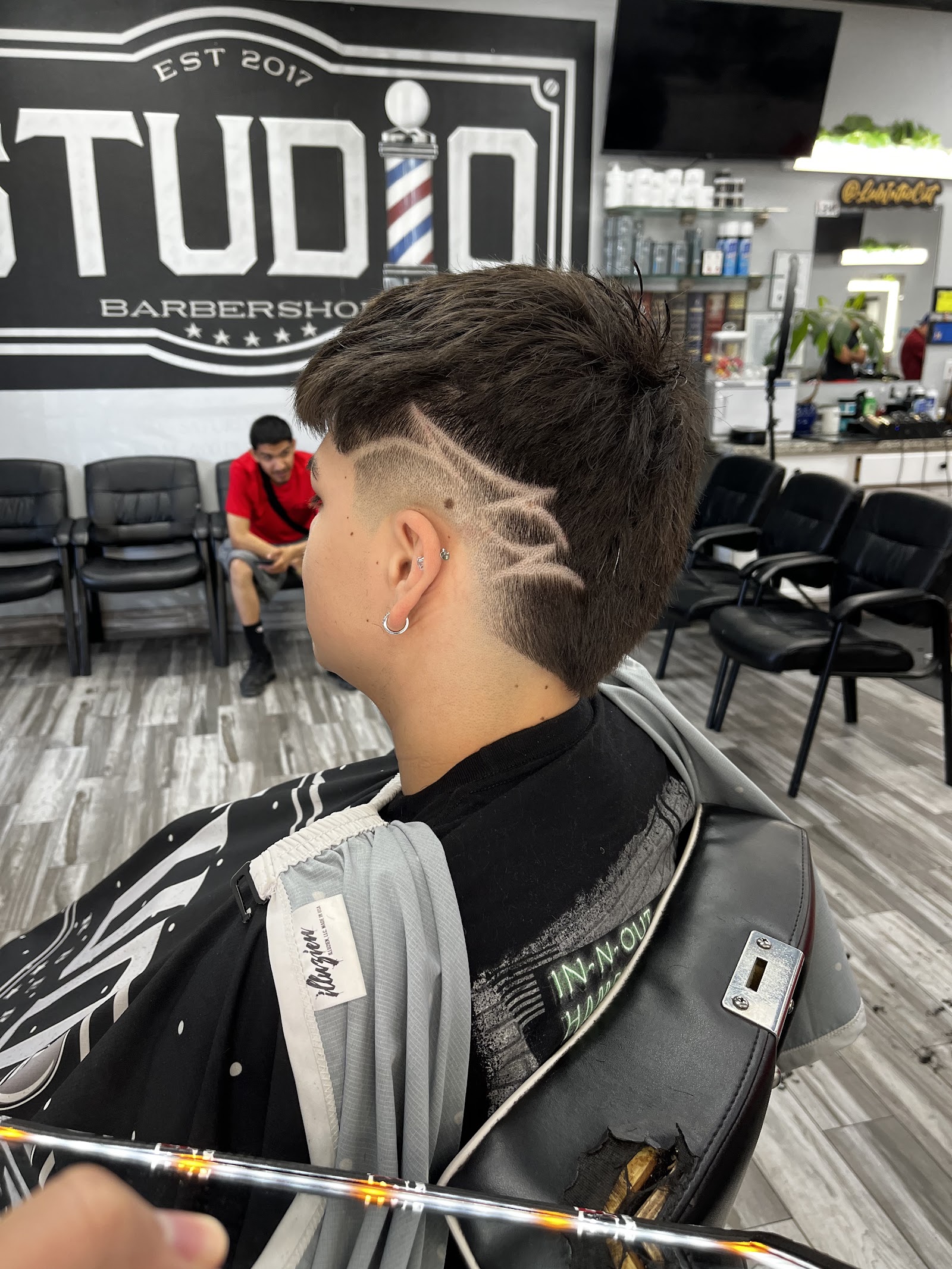 Detailed hair design shaved into the side of a client's head at Studio Barbershop